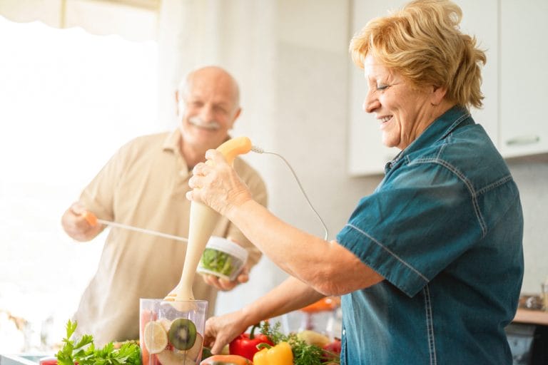 An elderly couple with high blood pressure preparing vegetables in the kitchen.