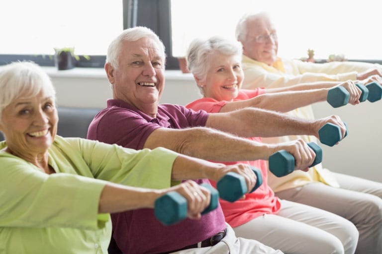 A group of elderly people exercising with dumbbells.