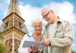 An older couple looking at a map in front of the eiffel tower.