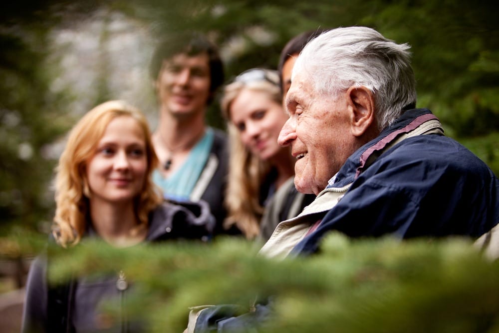 A group of people improving quality of life for a senior in the woods.