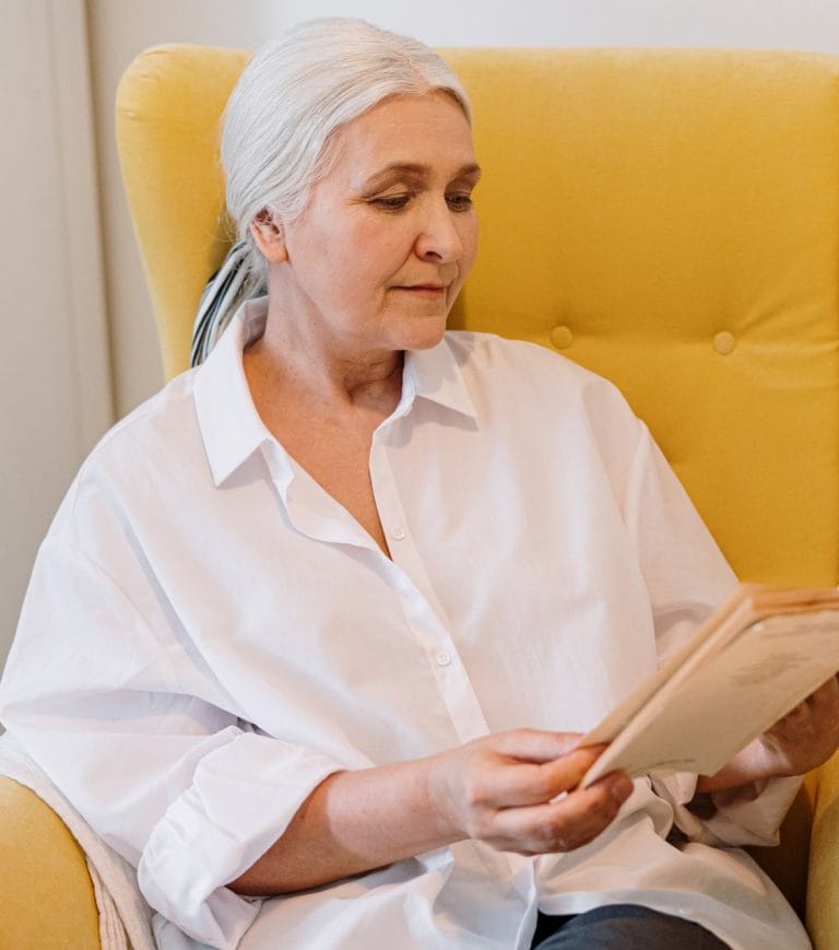 A woman is sitting in a chair managing medication.