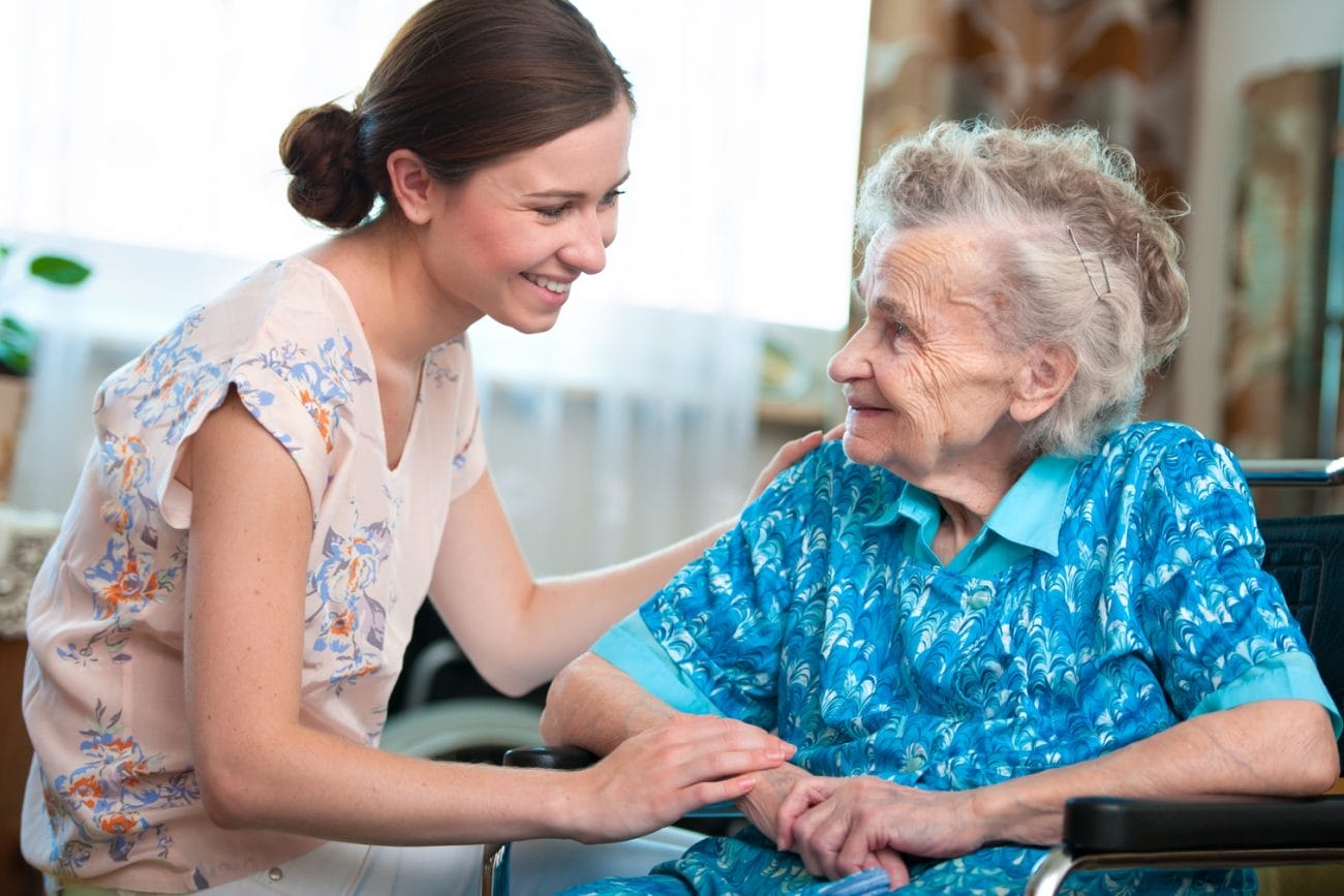 A woman is providing Ohio home care to an elderly woman in a wheelchair.