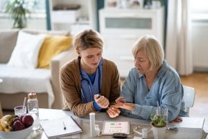 A nurse is helping an elderly woman with her medication.