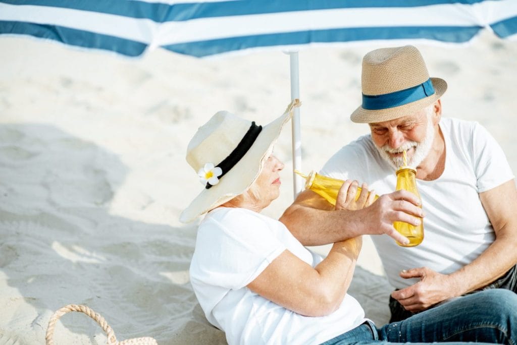 An elderly couple enjoying the beach while being assisted by Hilliard Home Care.