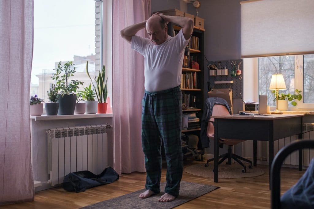 A man doing yoga in his bedroom.
