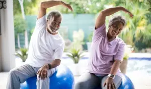 An older couple engaging in activities for seniors involving exercise balls.