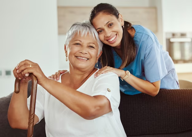 A nurse and an elderly woman posing for a photo during home care.