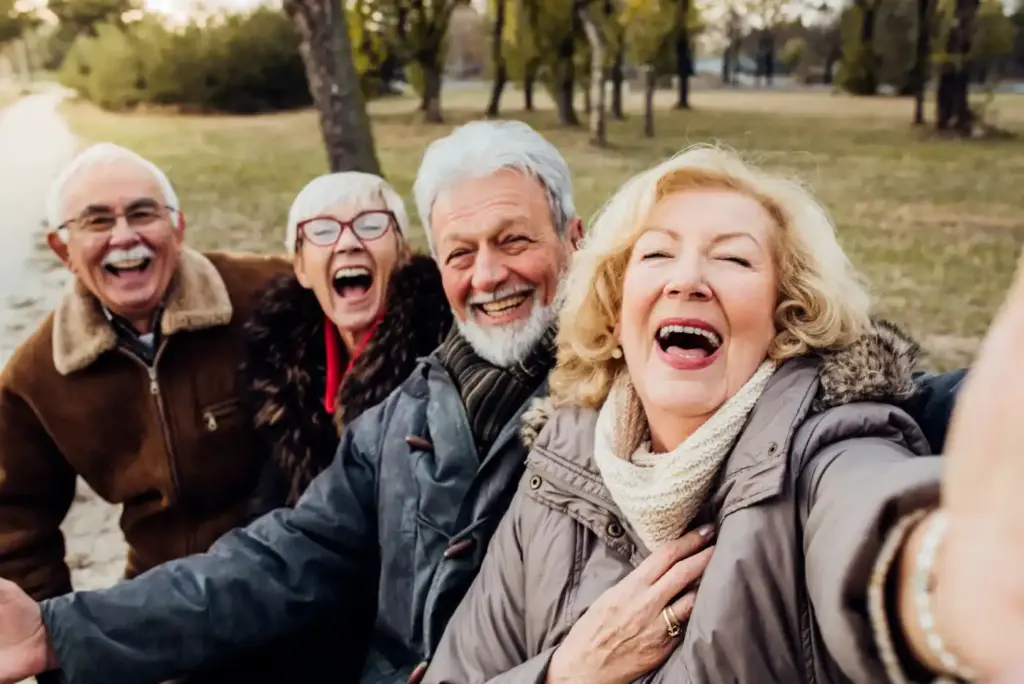 A group of older people taking a selfie in a park.