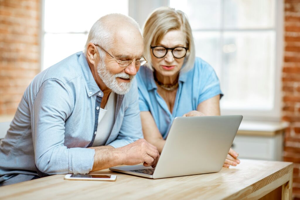 Senior couple with laptop at home