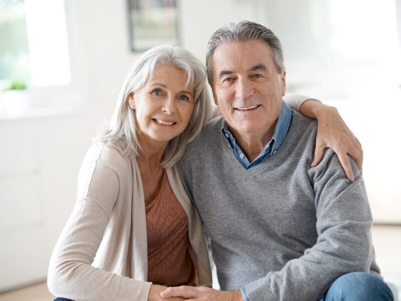 An older couple sitting on the floor in their post-hospital home.