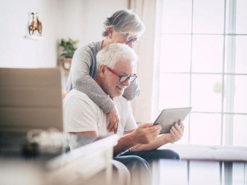 An elderly post-hospital couple using a tablet computer at home.