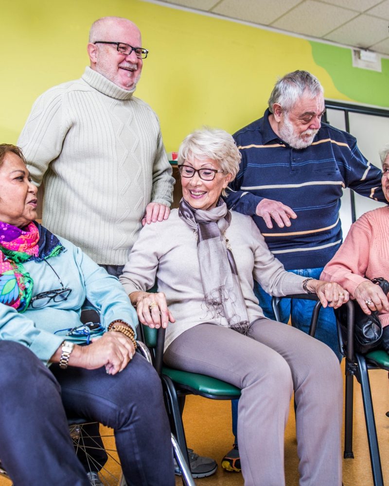 A group of elderly people sitting in a wheelchair.